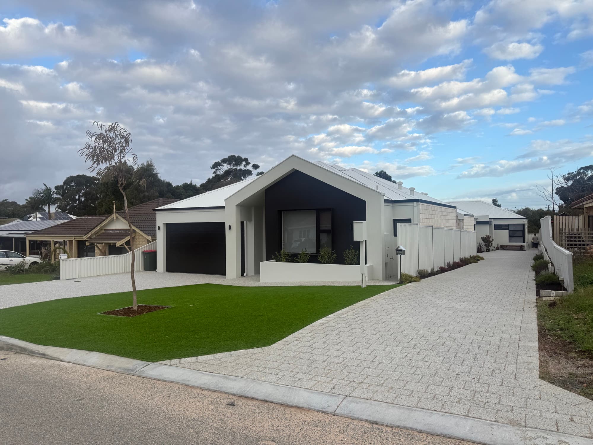 Freshly painted modern home exterior in off-white render with a black gable feature, painted by Brew Painting in Perth